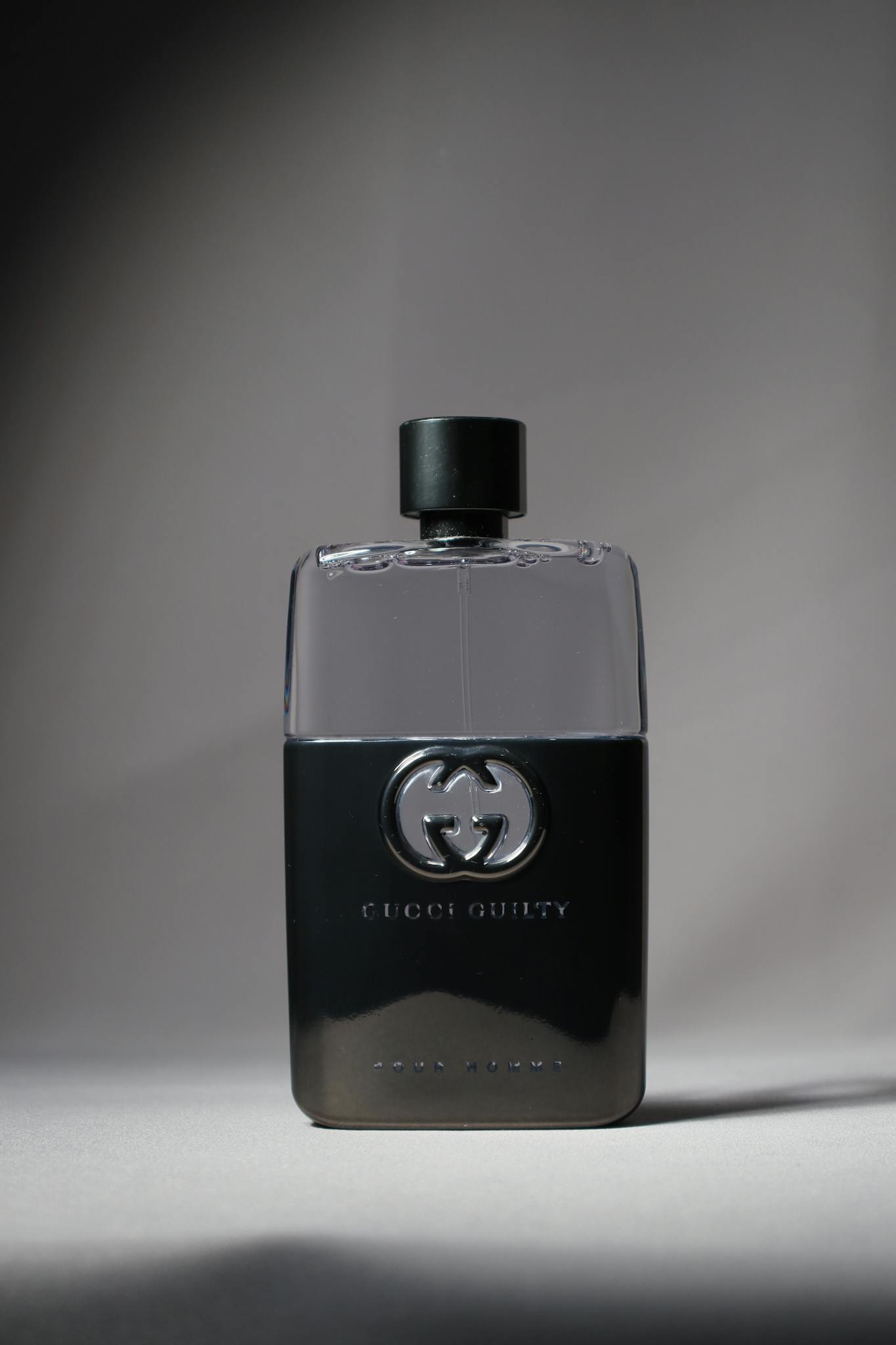 Elegant image of a Gucci Guilty perfume bottle in black with a stylish shadow.